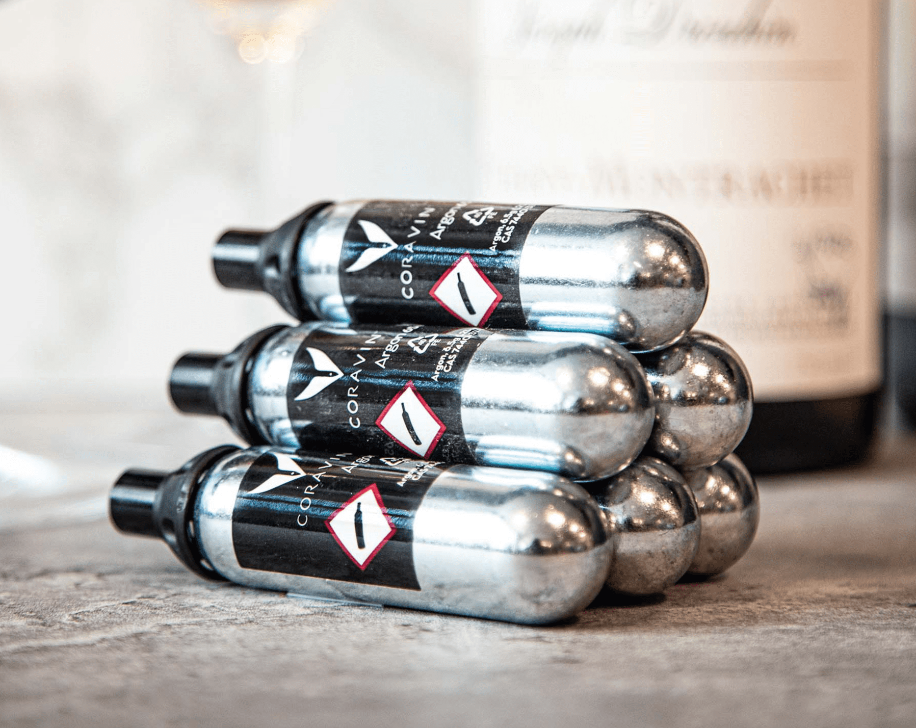 Stack of Co2 canisters on a wooden surface with a blurred background