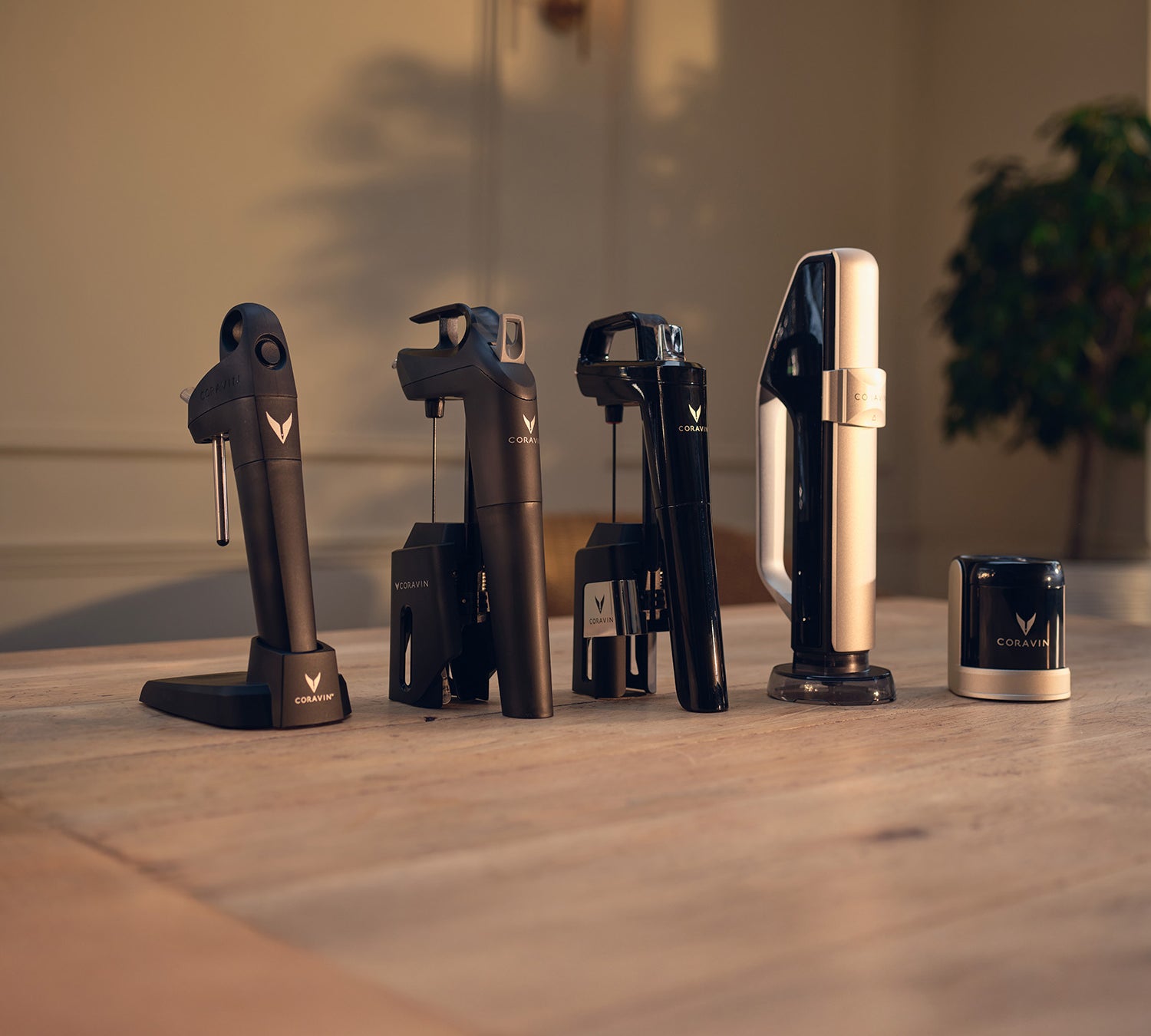Collection of Coravin wine bottle openers on a wooden surface with a blurred background