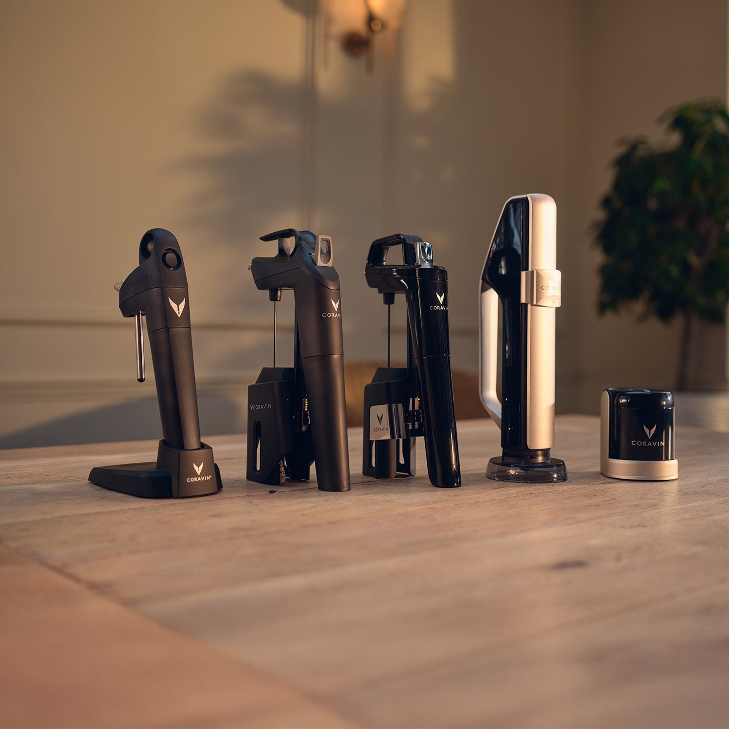 Collection of Coravin wine bottle openers on a wooden surface with a blurred background